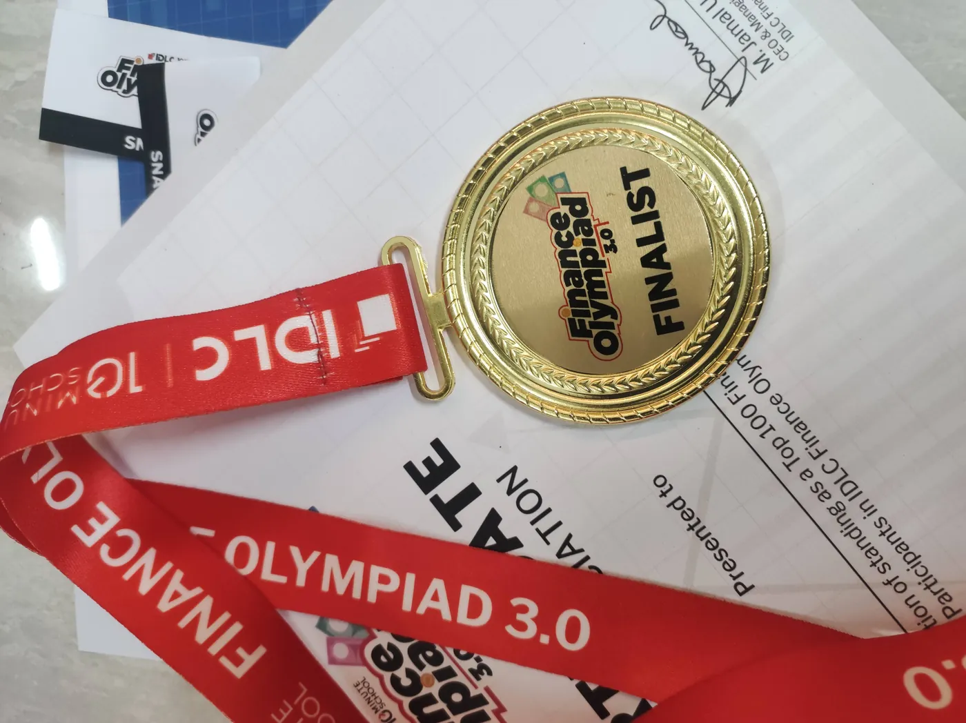 Finalist medal resting on a participation certificate