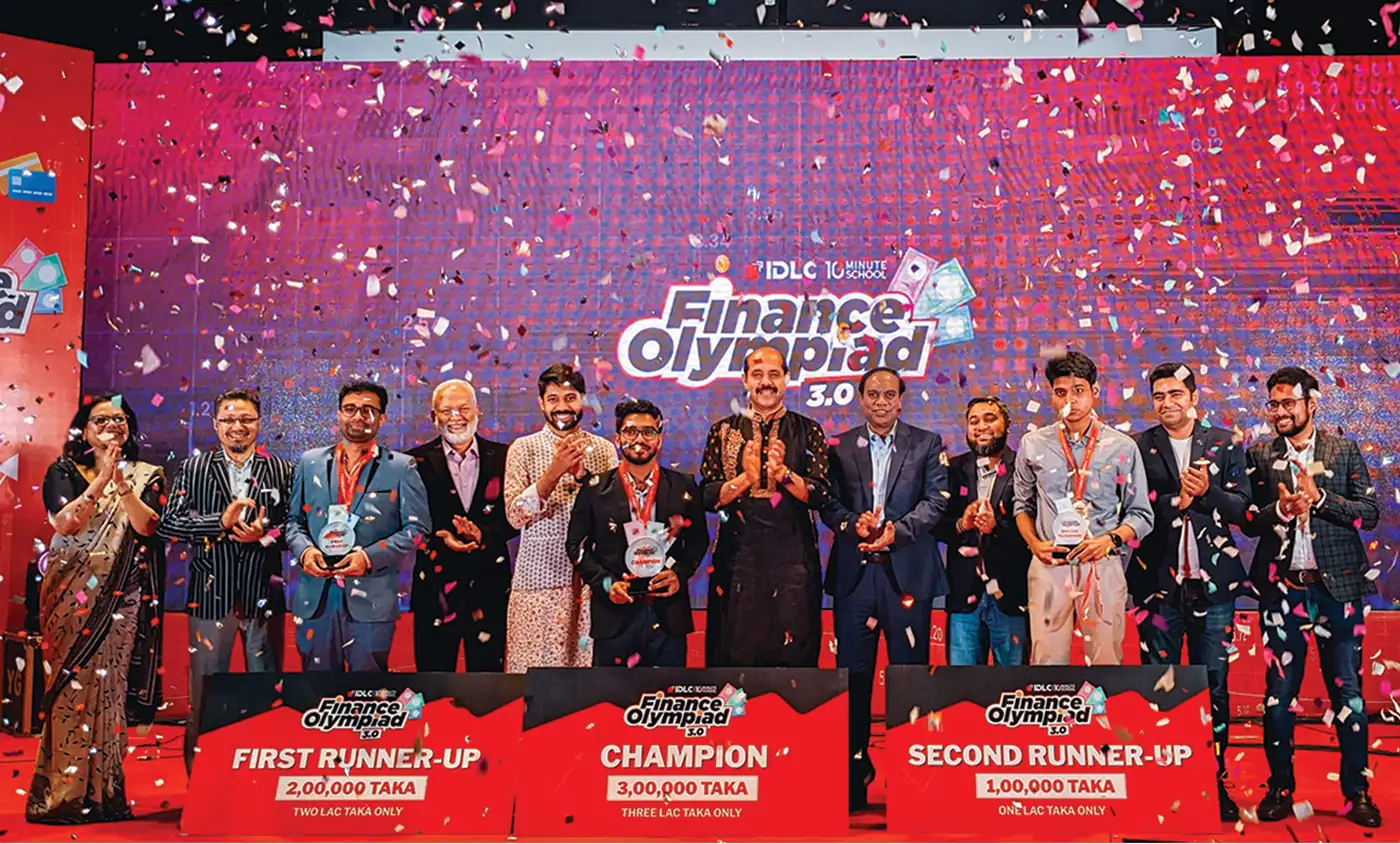 The gala stage: the Finance Olympiad 3.0 logo on the LED wall, the champion and runners-up holding the prize boards under confetti
