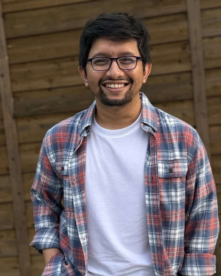 Sakib Bin Rashid smiling in a plaid shirt