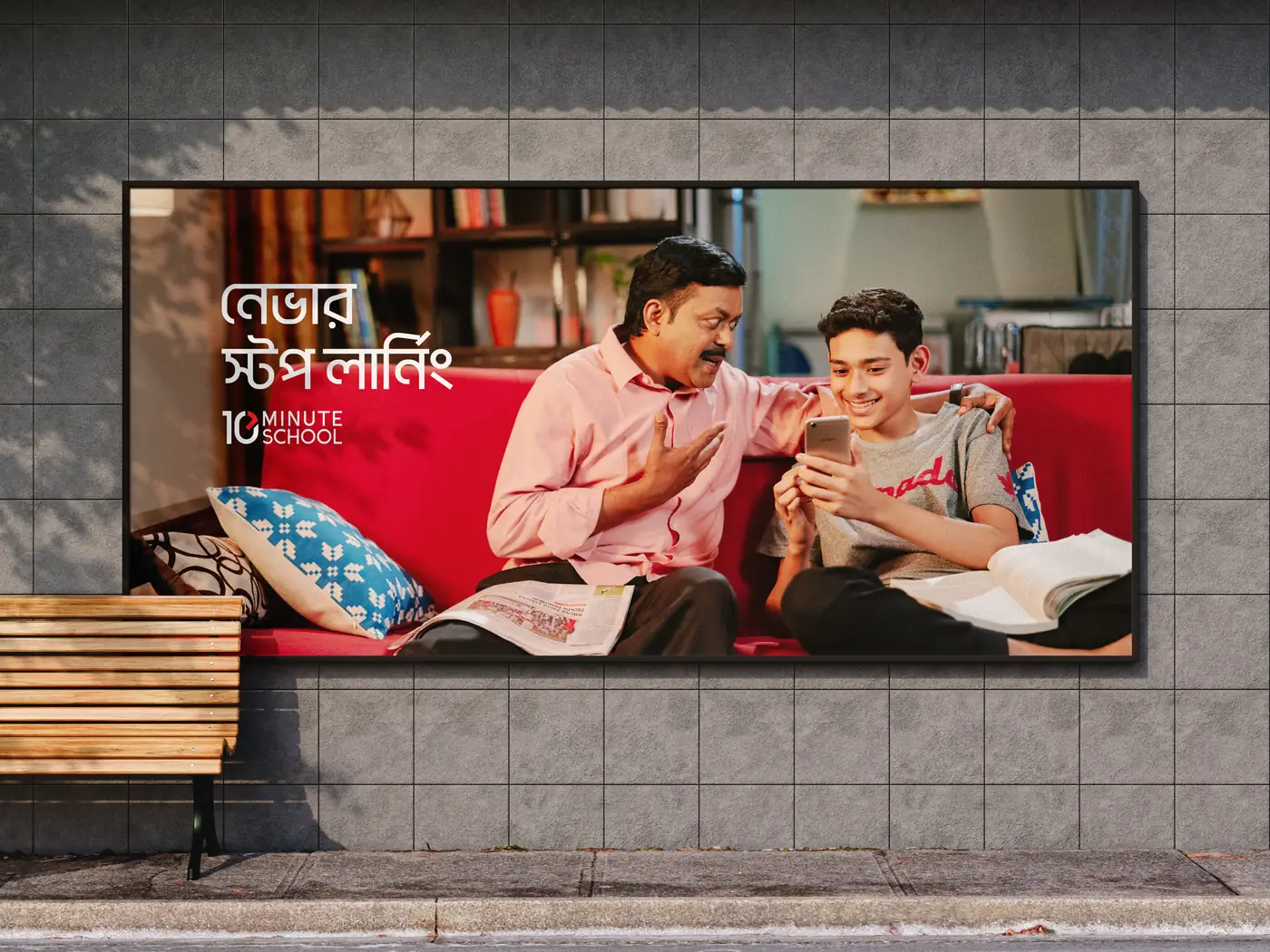 Street billboard above a bench: father and son on a red sofa