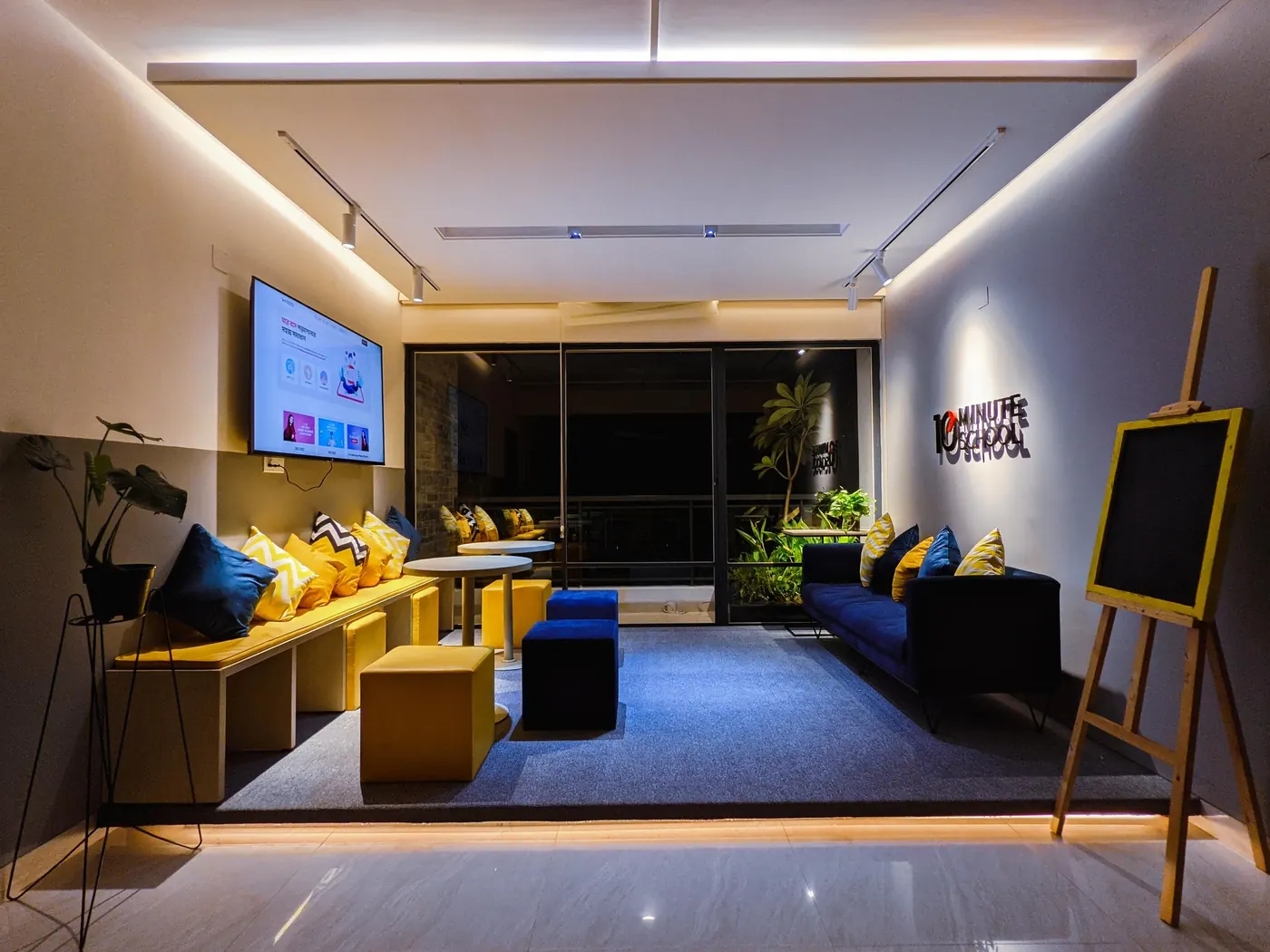 Office lounge with yellow and blue seating and the logo on the wall