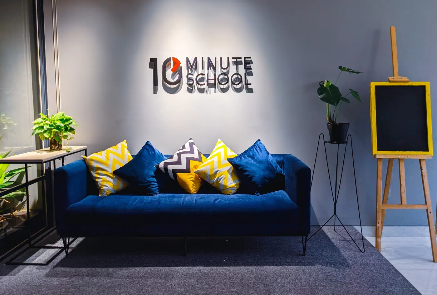 Blue sofa in front of a logo wall