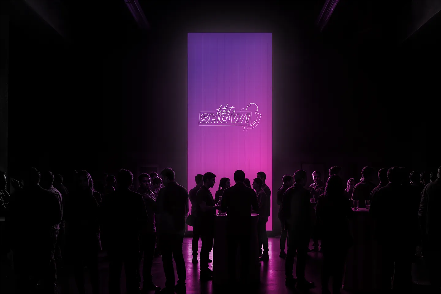 A tall stage screen with the sign above a crowd